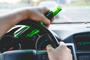 car driver with alcoholic drink in hand about to get a DUI