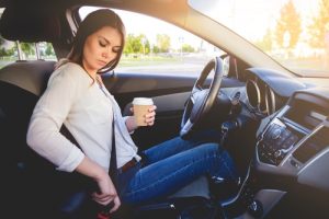 woman putting on seatbelt
