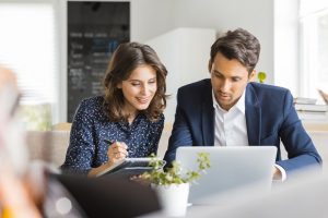 Young couple sitting in front of laptop 